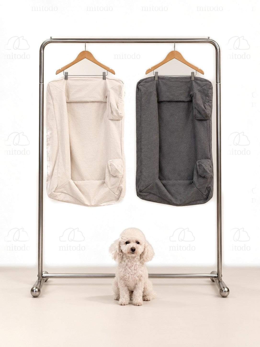 Kumo Bed Extra Covers in both colours hanging on a rail, with a white poodle sitting below