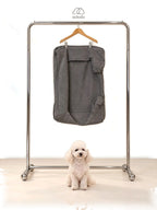 Mitodo Kumo Bed Extra Cover in Charcoal Gray hanging on a rail, with a white poodle sitting below